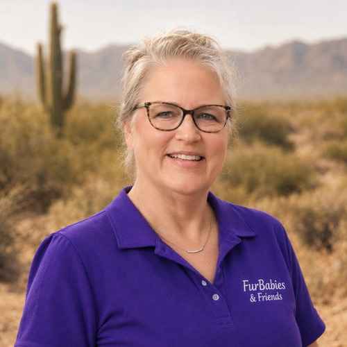 A FurBabies & Friends team member, Sherri Newport, in a purple polo poses against a desert background while representing positive in-home dog training in Peoria.