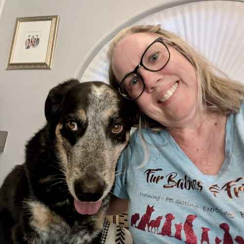 A FurBabies & Friends pet sitter poses with a black, white, and tan dog during a drop-in pet-sitting visit in Glendale.