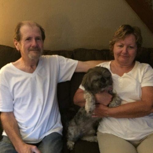 Shih Tzu Merlin snuggled contently with his new family on his Gotcha Day.