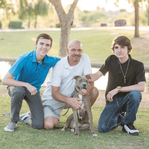 Furbabies & Friends 2022 Fall Family Photoshoot and family and their grey pitbull during their professional family photo shoot in Glendale, AZ.