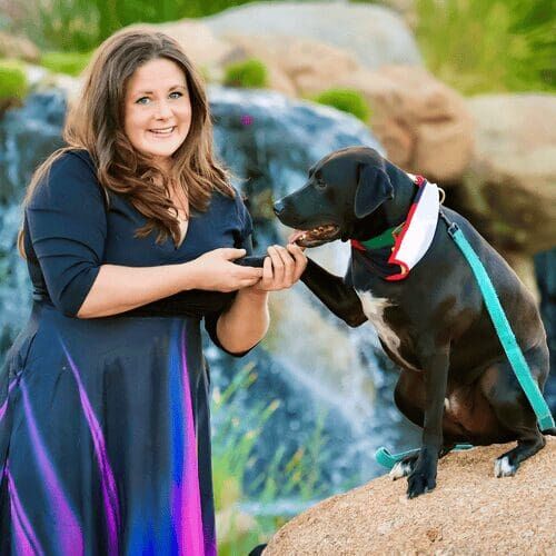 Apollo, Kristie's devoted training demonstration dog, holding hands with his owner Kristie Halverson, head of dog training of FurBabies & Friends in Glendale, AZ.