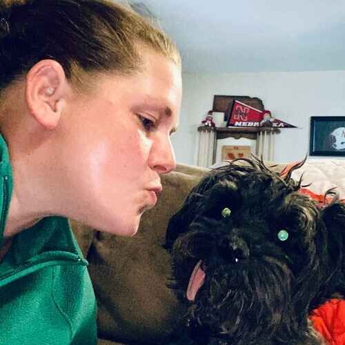 Kristie the pet sitter showing affection toward a small black special needs dog in Glendale AZ