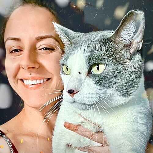 Pet sitter Brittany posing while holding a grey and white cat during overnight pet sitting in Phoenix AZ