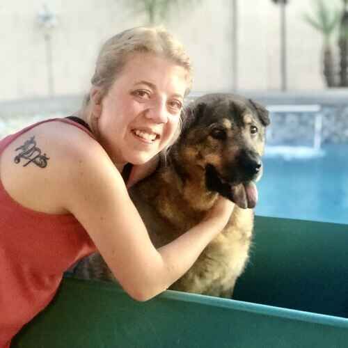 Pet sitter Hannah hugging a Chow Shepherd mix during an in-home pet sitting visit in Glendale AZ