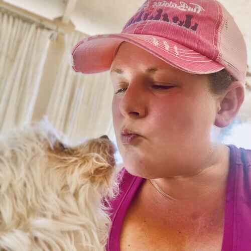Pet sitter Kristie giving kisses to a small Yorkie mix in Phoenix AZ