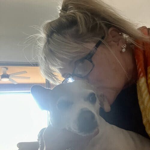 Pet sitter Michelle kissing a small dog's head during overnight pet sitting in Phoenix AZ