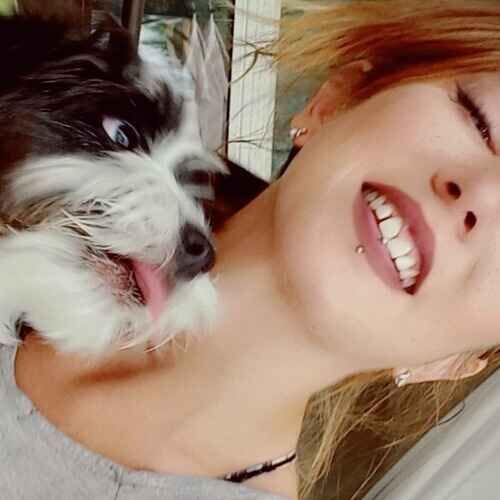 Pet sitter Sandra getting kisses from a black and white dog during pet sitting in Glendale AZ