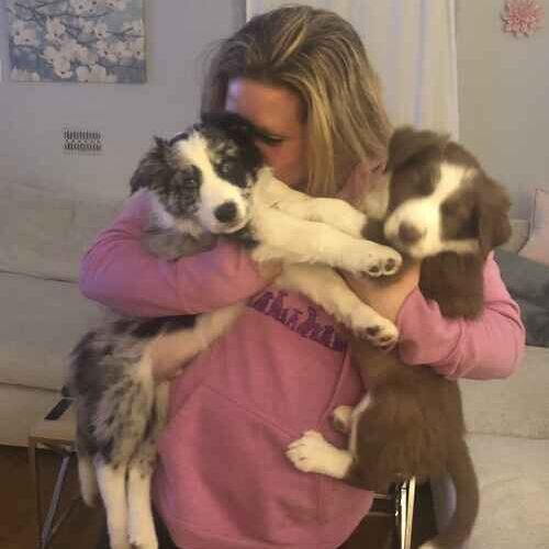 Puppy trainer Kristie from FurBabies & Friends snuggling two Aussie puppies during in-home puppy training in Phoenix AZ