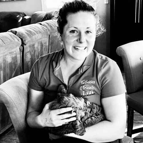 Positive reinforcement dog trainer Kristie holding a tired puppy during in-home puppy training in Glendale AZ