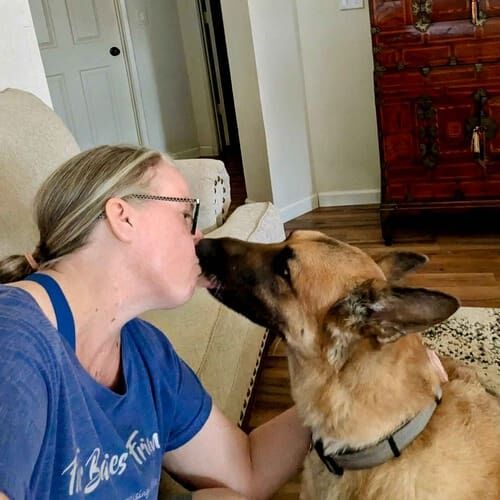 Senior German Shepherd Rocky kisses dog sitter Karen during a dog sitting visit in Phoenix, AZ